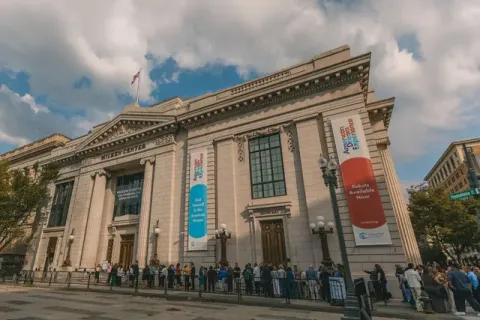 Visitors line around the building.